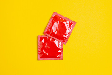 two condoms lie on a yellow background, the concept of safe sex