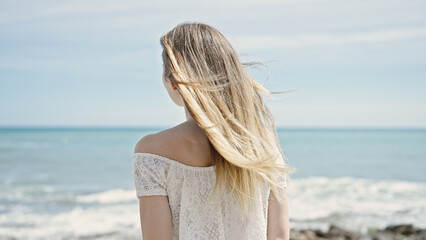 Fototapeta na wymiar Young blonde woman tourist standing backwards at beach