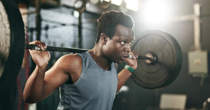 Black man at gym, weight lifting and barbell for muscle building endurance, strong body or balance power in fitness. Commitment, motivation and bodybuilder in workout challenge in health and wellness