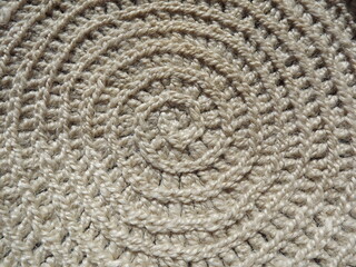 Crocheting of jute, yarn, raffia white in a circle close-up as a background
