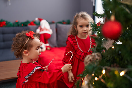 Adorable girls decorating christmas tree at home
