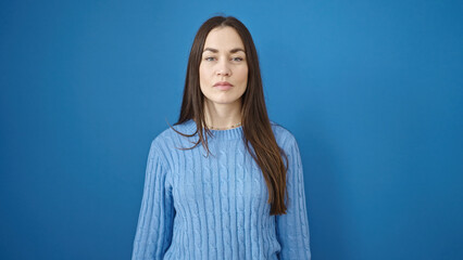 Young caucasian woman standing with serious expression over isolated blue background