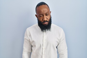 Obraz premium African american man standing over blue background skeptic and nervous, frowning upset because of problem. negative person.