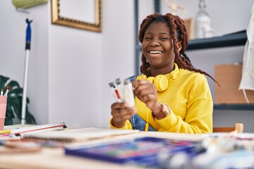 African american woman artist smiling confident choosing color at art studio