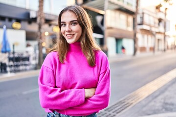 Fototapeta premium Young woman smiling confident standing with arms crossed gesture at street