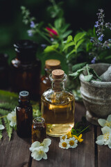Assortment of pure organic natural essential aroma oil with mint , camomile on wooden background. Concept of herbal, floral ingredients in cosmetology. Alternative medicine, therapy, Ayurveda