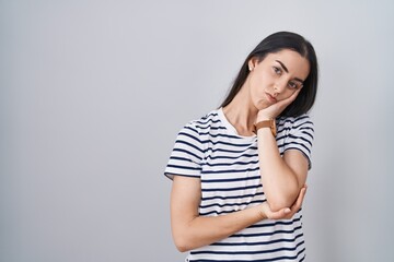 Obraz premium Young brunette woman wearing striped t shirt thinking looking tired and bored with depression problems with crossed arms.
