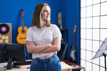 Young woman artist standing with arms crossed gesture at music studio