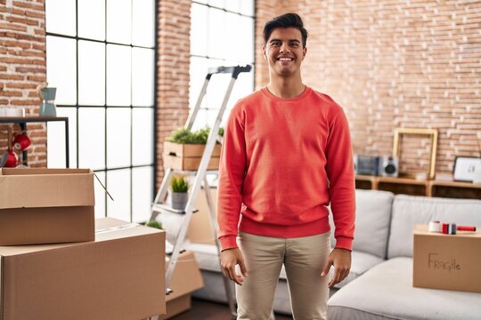 Hispanic man moving to a new home with a happy and cool smile on face. lucky person.