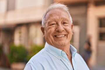 Fototapeta na wymiar Senior grey-haired man smiling confident standing at street
