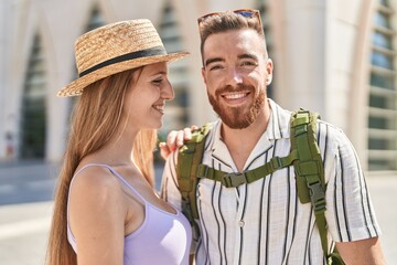 Obraz premium Man and woman tourist couple smiling confident hugging each other at street