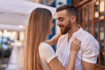 Man and woman couple smiling confident hugging each other at street