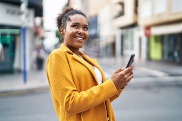 African american woman smiling confident using smartphone at street