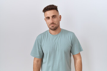 Obraz premium Hispanic man with beard standing over white background depressed and worry for distress, crying angry and afraid. sad expression.