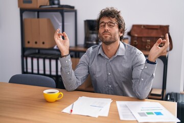 Young hispanic man business worker doing yoga exercise at office