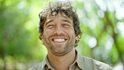 Young hispanic man smiling confident standing at park