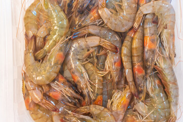 Shrimp on ice in a store fridge, background