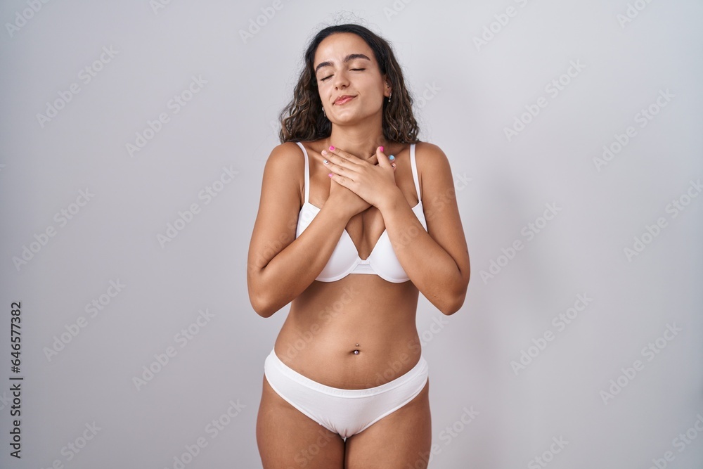 Canvas Prints Young hispanic woman wearing white lingerie smiling with hands on chest with closed eyes and grateful gesture on face. health concept.