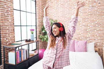 Young beautiful arab woman listening to music and dancing at bedroom