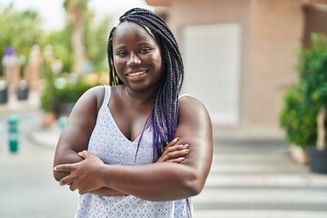 African american woman standing with arms crossed gesture at street