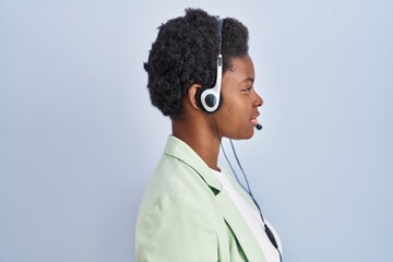 African american woman wearing call center agent headset looking to side, relax profile pose with...