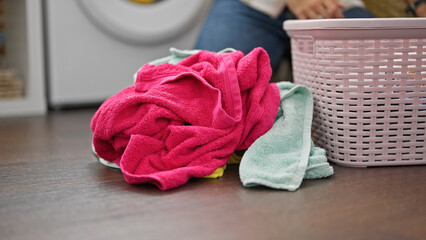 Obraz na płótnie Canvas Young hispanic man washing clothes at laundry room