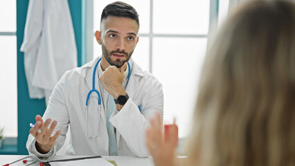 Young hispanic man doctor having medical consultation at the clinic