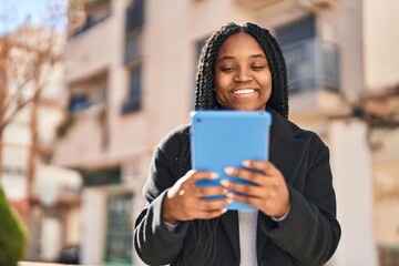 African american woman smiling confident using touchpad at street