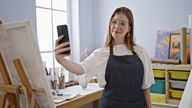 Young blonde woman artist make selfie by smartphone smiling at art studio