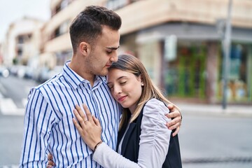 Man and woman couple smiling confident hugging each other at street