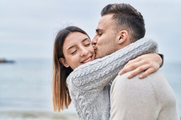 Obraz premium Man and woman couple hugging each other kissing at seaside
