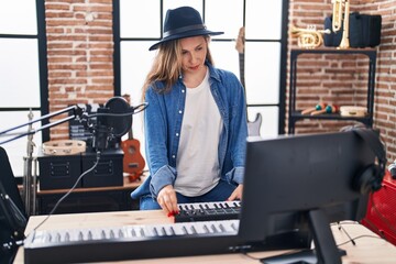 Young blonde woman musician having dj session at music studio