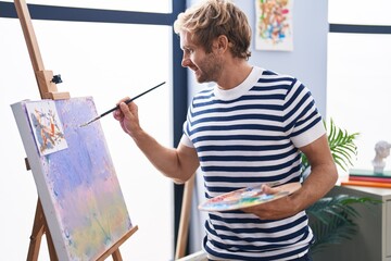 Young man artist smiling confident drawing at art studio