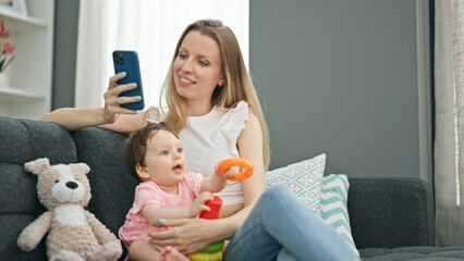 Mother and daughter using smartphone while playing with hoops at home