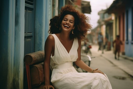 Smiling Woman Sitting On A Bench In The Street In A White Dress