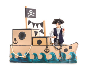 Cute little pirate with smoking pipe in cardboard ship on white background