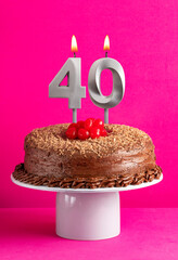 Number 40 candle - Chocolate cake on pink background