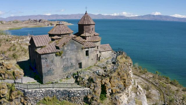 Tilt down aerial shot of Hayravank Monastery and Sevan Lake on sunny summer day. Gegharkunik Province, Armenia.