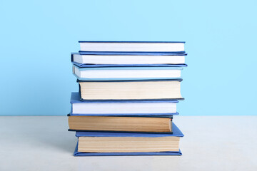 Stack of books on table against blue background