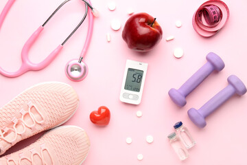 Glucometer, sneakers, apple, dumbbells and pills on pink background. Diabetes concept
