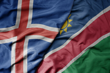 big waving national colorful flag of icelandic and national flag of namibia .
