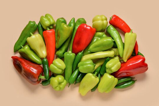 Assortment of fresh red green and yellow bell peppers and chili peppers on a light brown background healthy eating, this colorful collection healthy eating organic produce and culinary ingredients