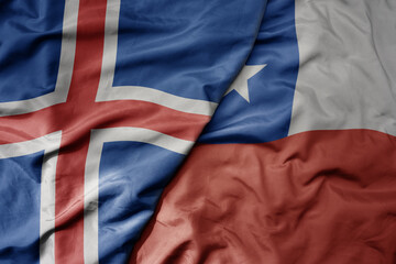 big waving national colorful flag of icelandic and national flag of chile .