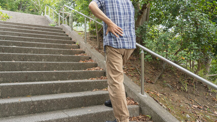 階段で息切れ・腰痛の男性　イメージ