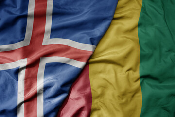big waving national colorful flag of icelandic and national flag of guinea .