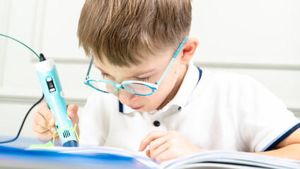 a boy draws with a 3d pen