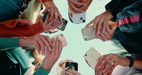 Friends group, circle and phone in low angle, campus or mobile connection with scroll, typing or click in summer. Girl students, smartphone and huddle for social network at high school in Los Angeles - Powered by Adobe