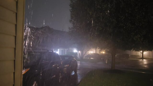 Heavy rain storm rain falls on street near family houses. Hard storm night