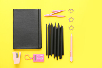 School stationery with pencils on yellow background