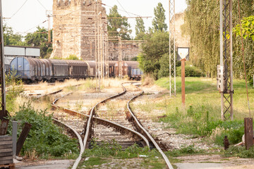 Selective blur on a rusty decaying rail yard and a train switch in a freight railway station, half...